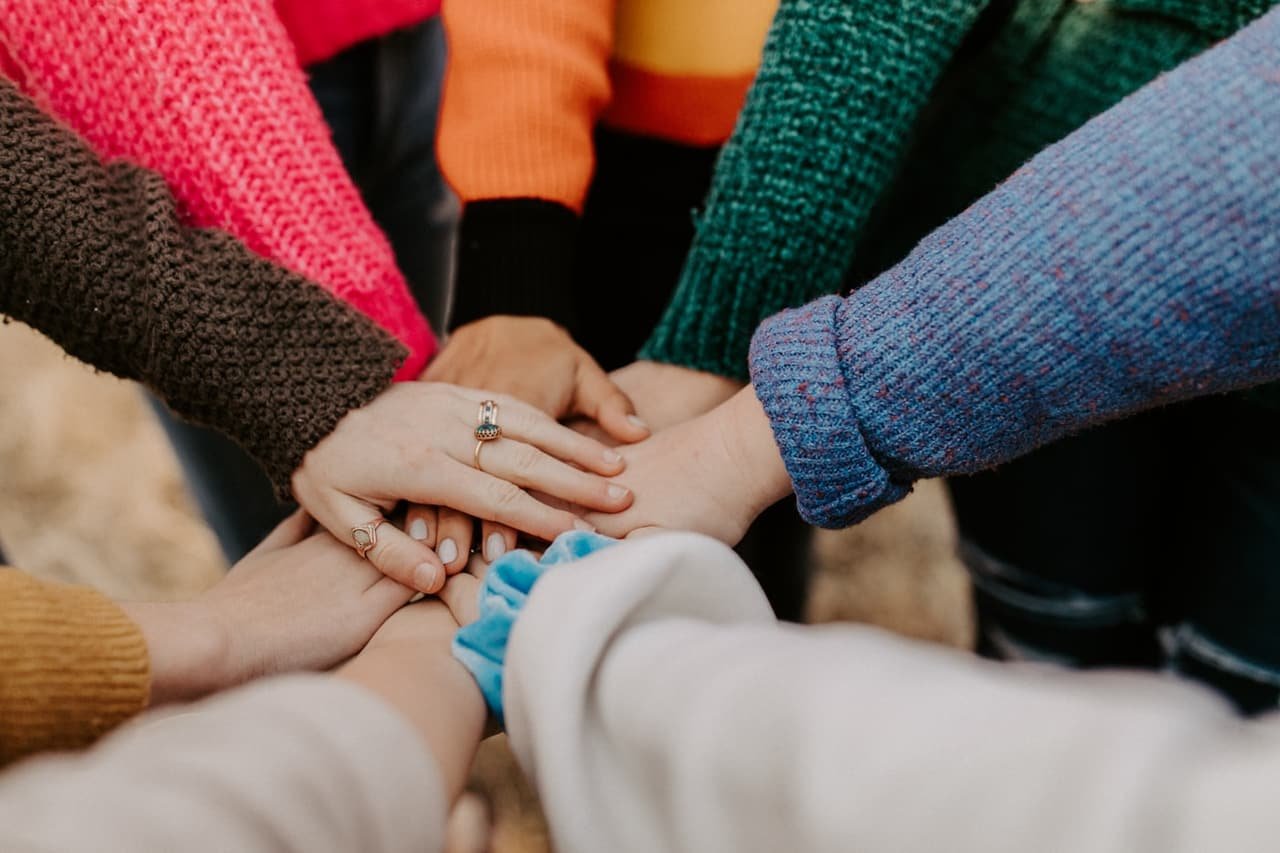 Community members joining hands together in unity